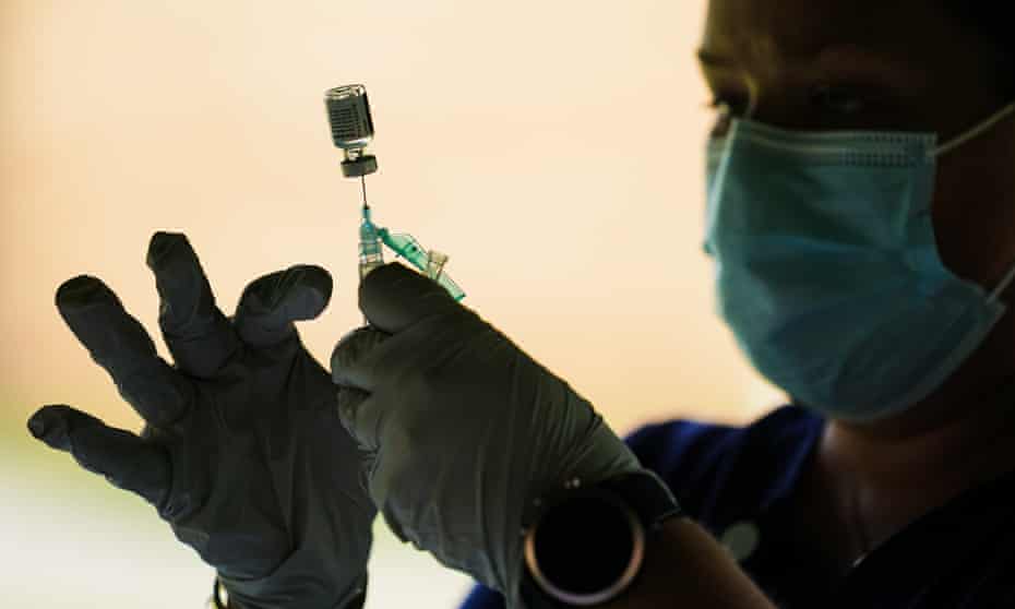 Shadow of medical worker holding needle located inside of a vial